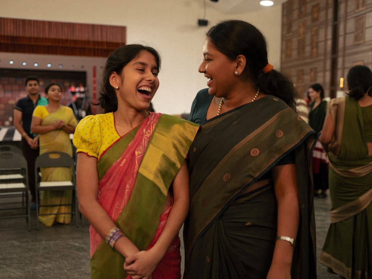 A girl in a half-sari laughs with her mother before her recital.